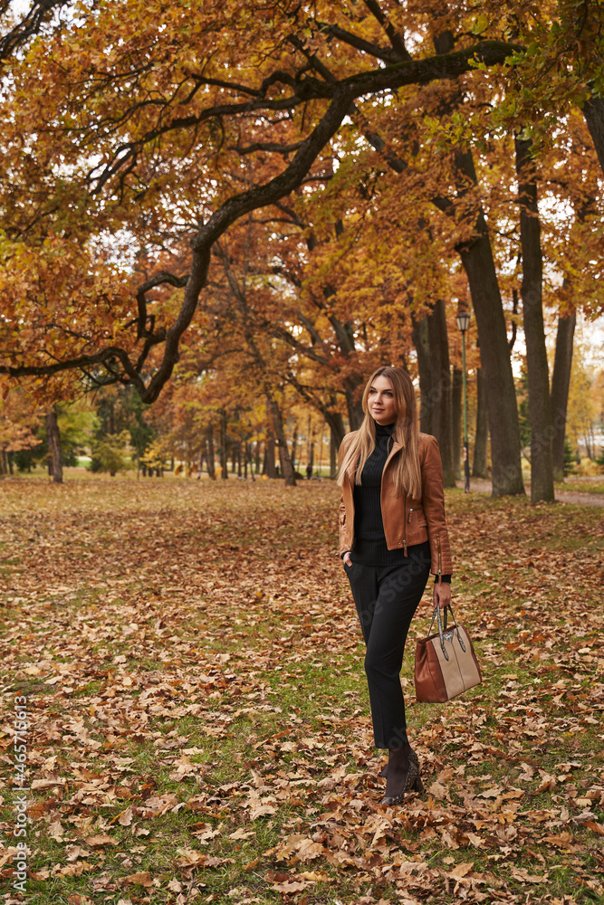 young beautiful woman stands in autumn park under yellow trees on yellow foliage young beautiful woman stands in autumn park under yellow trees on yellow foliage