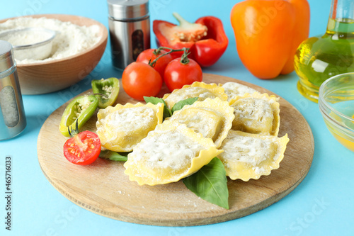 Concept of cooking ravioli on blue background