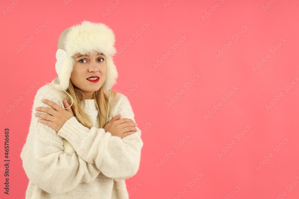 Attractive girl in fur cap and sweater on pink background Attractive girl in fur cap and sweater on pink background