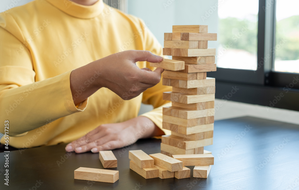 Hands of businesswomen playing wooden block game. Concept Risk of management and strategy plans for business growth and success Hands of businesswomen playing wooden block game. Concept Risk of management and strategy plans for business growth and success