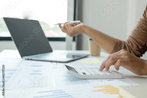 work from home  The hand of a woman who works in finance sits at his desk at home and calculates financial graphs showing the results of his investments  planning the steps of his business growth