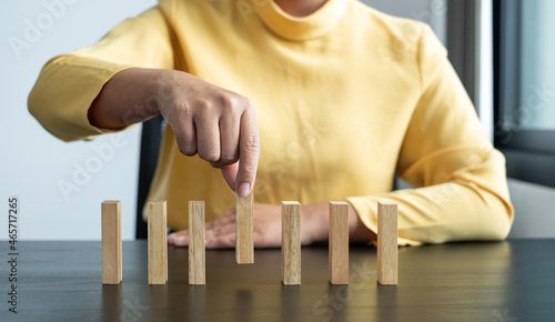 Hands of businesswomen playing wooden block game. Concept Risk of management and strategy plans for business growth and success