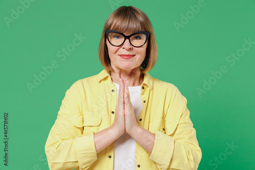 Принти на полотні Elderly asking happy caucasian woman 50s in glasses yellow shirt hands folded in