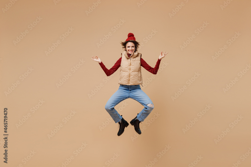 Obraz premium Full body spiritual young woman wears red turtleneck vest beret hold spreading hands in yoga om aum gesture relax meditate try to calm down isolated on plain pastel beige background studio portrait