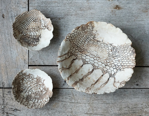 Modern ceramic wall plates with lace pattern on a wooden board