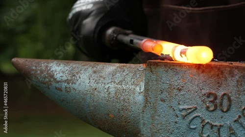 Blacksmith pounding on gun barrel