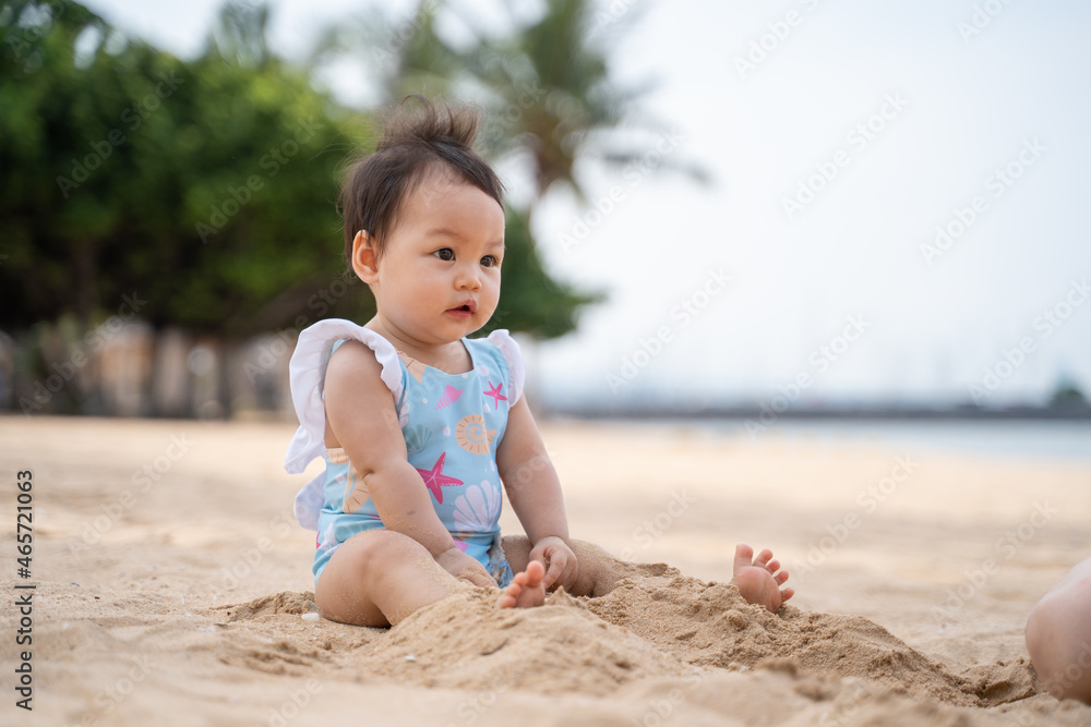 baby infant playing in the sea water and waves on sand beach in morning sunny day. 9 months old baby activity outdoor beach vacation. baby infant playing in the sea water and waves on sand beach in morning sunny day. 9 months old baby activity outdoor beach vacation.