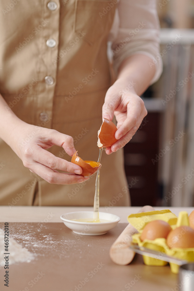 Process of young woman separating egg yolk from white when making dough for pastry Process of young woman separating egg yolk from white when making dough for pastry