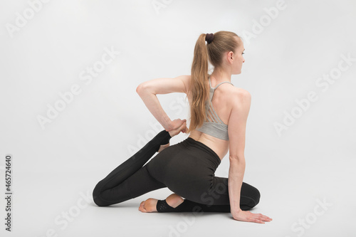 Eka Pada Rajakapotasana. Pigeon Pose. Young slender woman does an exercise for flexibility. Girl is engaged in gymnastics or yoga.