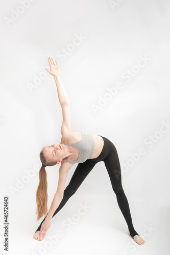 Teenage girl is engaged in gymnastics. Young woman is doing exercises. Set of exercises for back health. Vertical frame