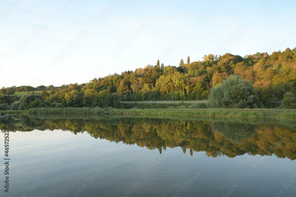 Canal de la Sarre en Moselle, l'automne se dessine à petit pas et les couleurs automnales des arbres se reflètent dans l'eau du canal
