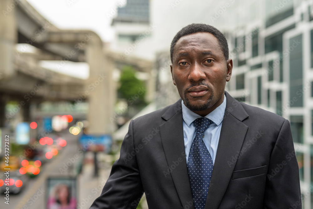 Fototapeta premium Portrait of handsome African businessman in city