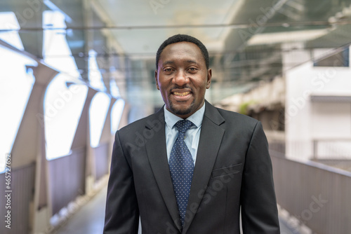 Portrait of handsome African businessman in city smiling