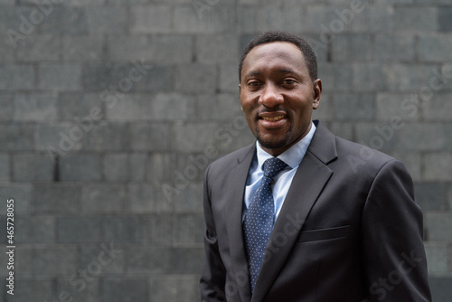 Photography Portrait of handsome African businessman in city smiling