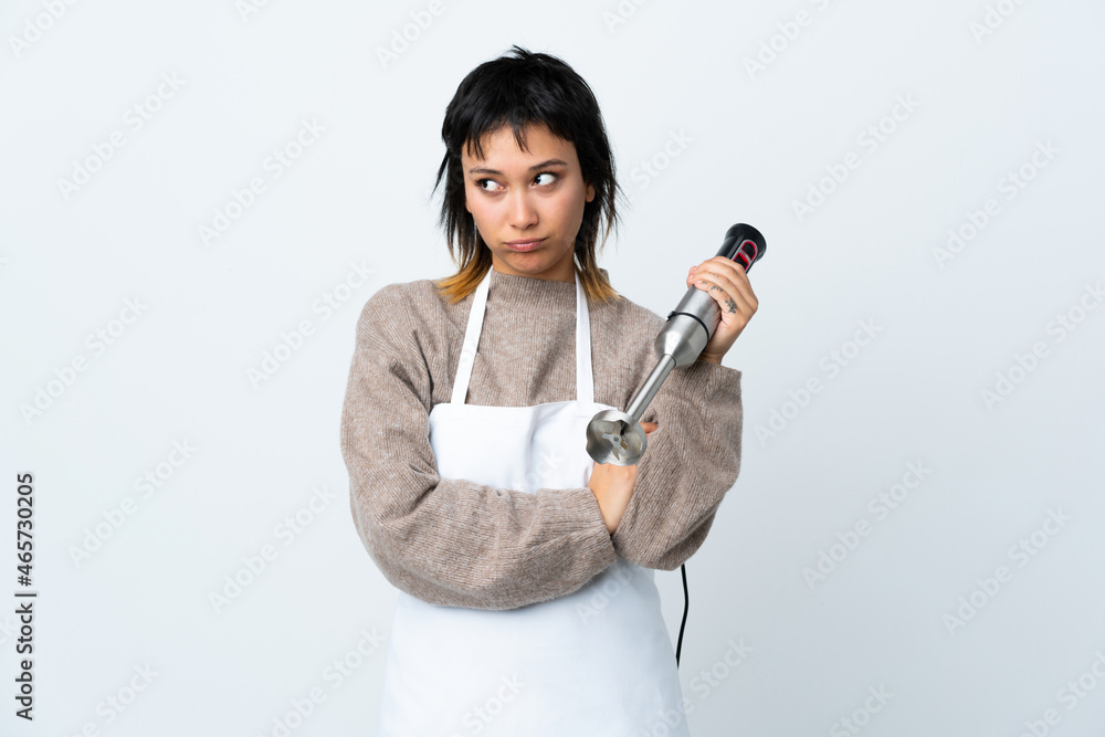 Chef Uruguayan girl using hand blender over isolated white background thinking an idea Chef Uruguayan girl using hand blender over isolated white background thinking an idea