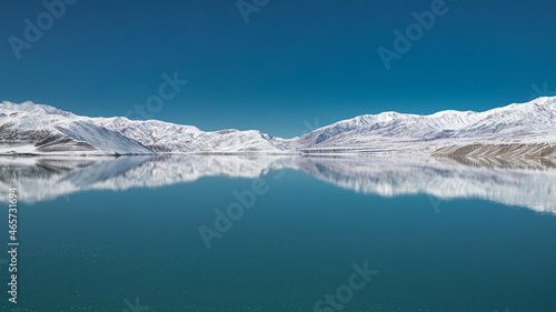 snow mountiain reflected in the white sand lake where located in Xinjiang province, China. 