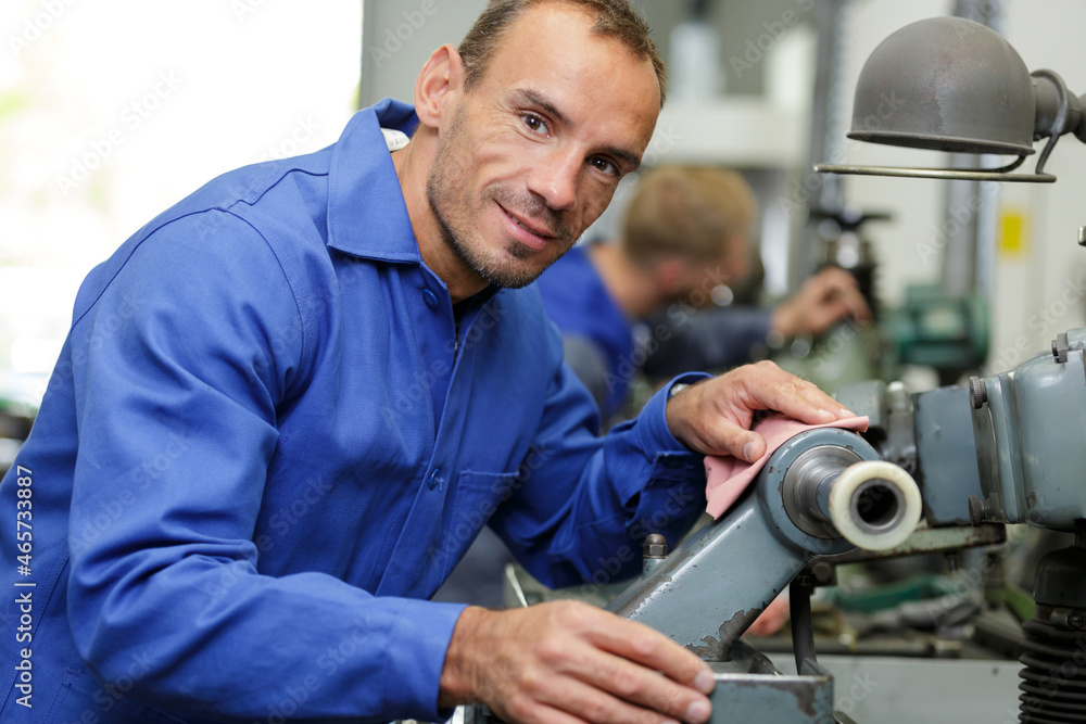 portrait of man cleaning industrial equipment portrait of man cleaning industrial equipment