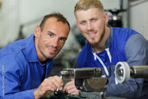two mechanics repairing the machine in the factory