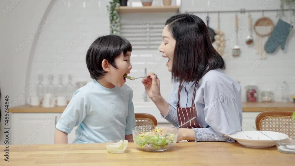 Asian happy family cooking in kitchen room at house.Mother is feeding her son salad to learn how to eat vegetables for health benefits.Family relationship
Asian happy family cooking in kitchen room at house.Mother is feeding her son salad to learn how to eat vegetables for health benefits.Family relationship