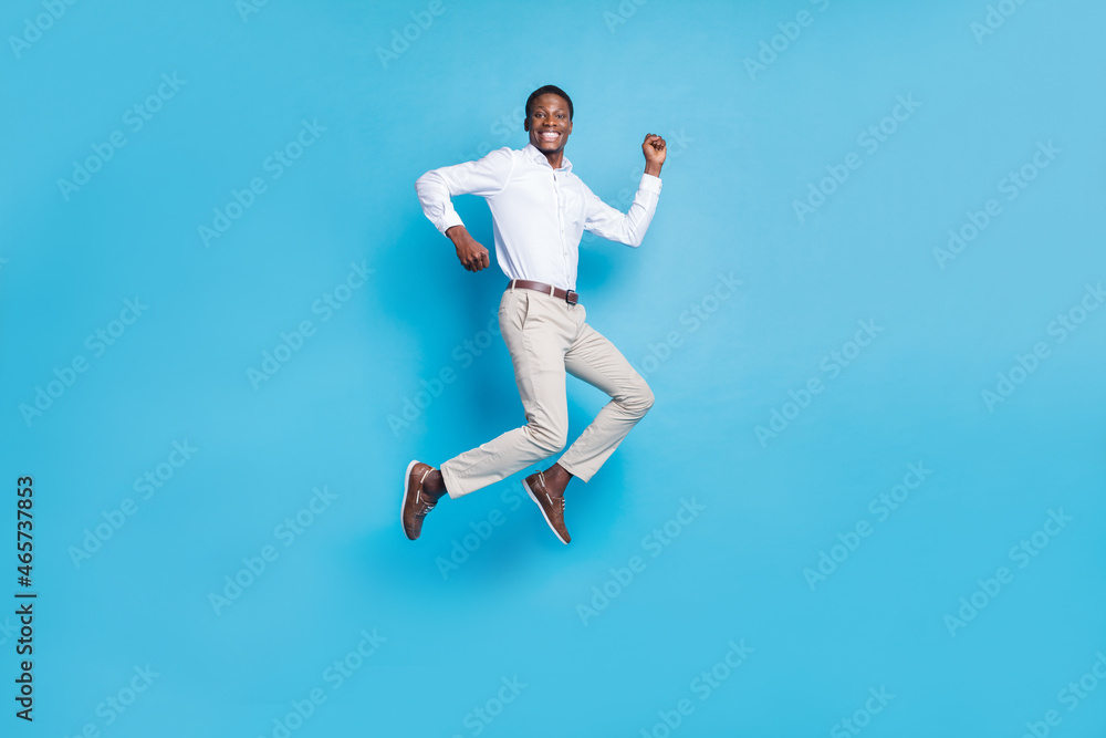 Photo of lucky pretty dark skin guy dressed formal shirt humping high rising fist smiling isolated blue color background