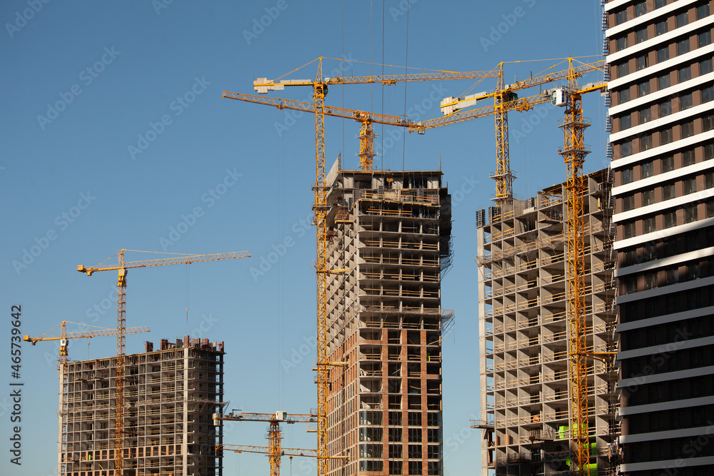 Construction site. Cranes and concrete buildings. Investing in new real estate. Construction site. Cranes and concrete buildings. Investing in new real estate.