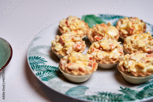 macrophotography of christmas canapes. crab stick tartlet with egg and mayonnaise on white background