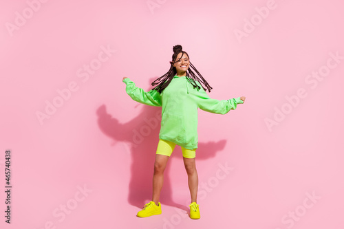 Full body photo of joyful dark skin young woman fly hair enjoy good mood isolated on pink color background