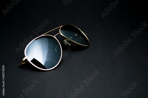 Single sunglasses and empty dark gray background.