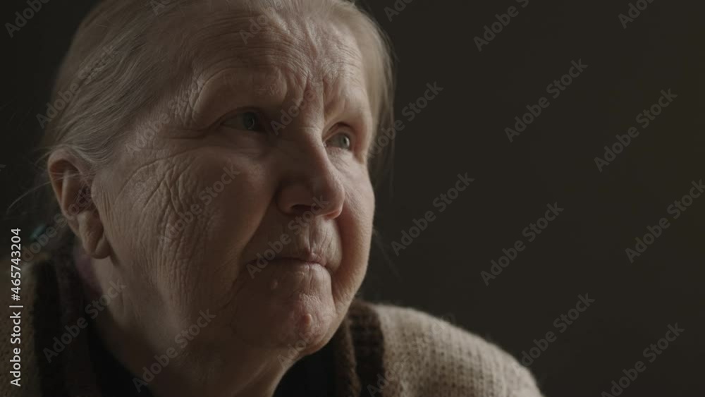 Senior woman sitting indoor with soft window light Senior woman sitting indoor with soft window light