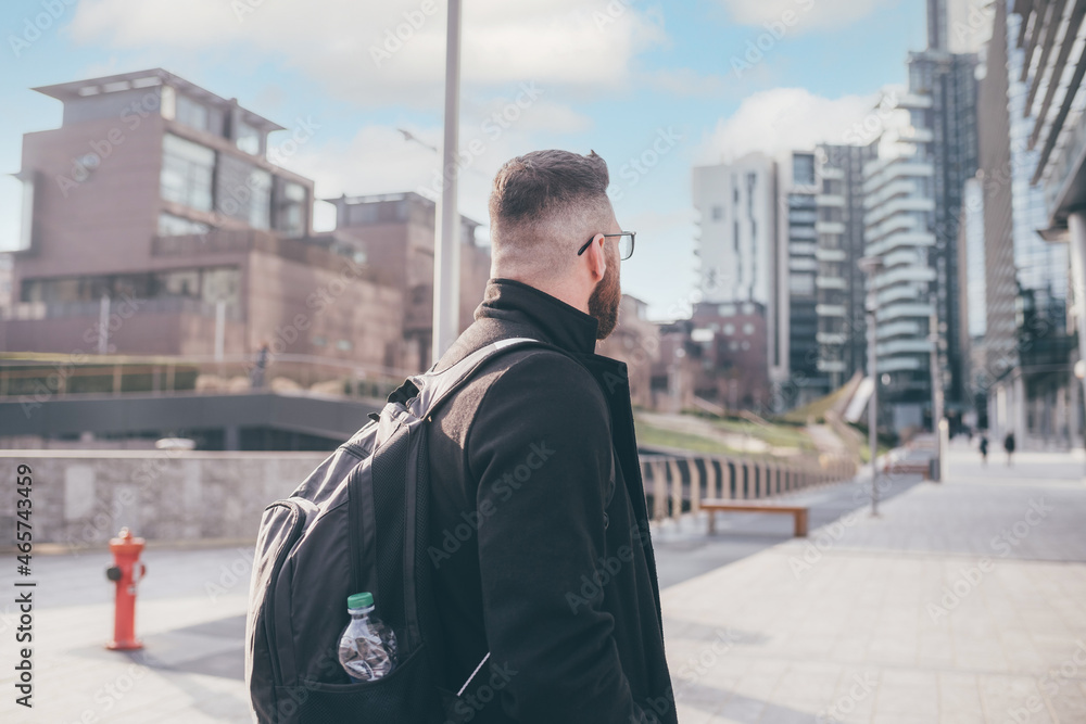 side view bearded adult man commuter backpack walking city going work city sunset side view bearded adult man commuter backpack walking city going work city sunset