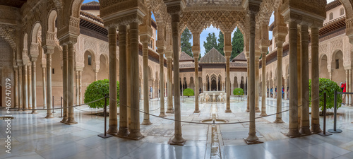 Full panoramic exterior view at the Patio at the Lions, twelve marble lions fountain on Palace of the Lions or Harem, Alhambra citadel, tourist people visiting photo