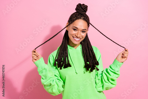 Photo of cheerful happy dark skin young pretty nice lady hold hands braids isolated on pink color background