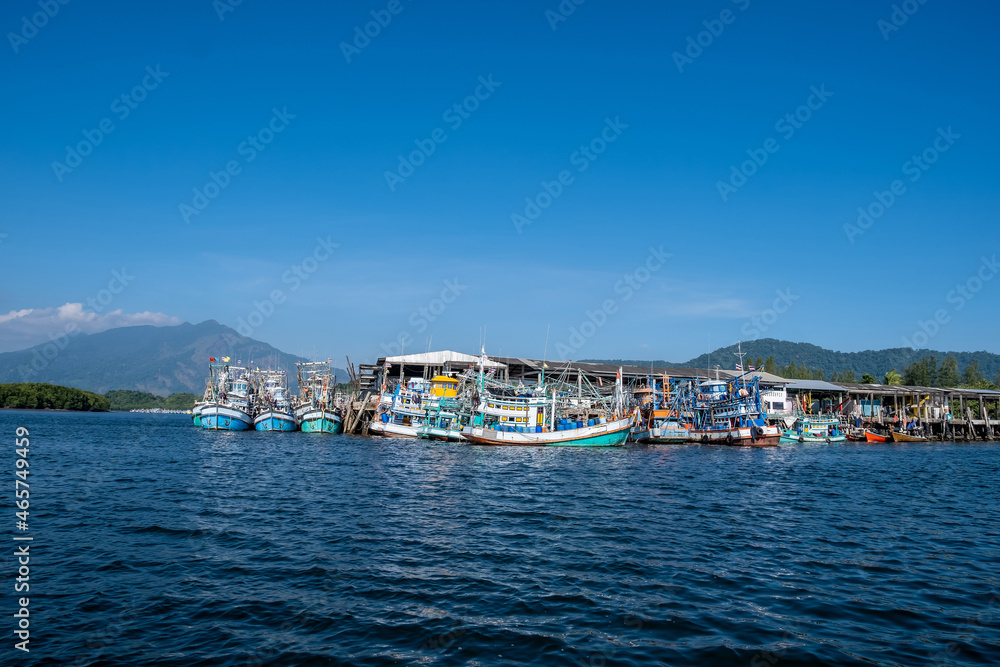 Fishing boats with beautiful scene of mountain and green mangrove forest in the evening. Coast near Andaman Sea and islands, Phang Nga province, Thailand.