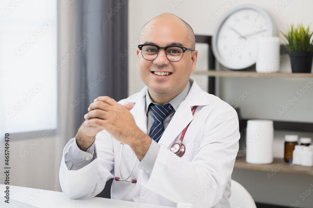 Young asian man doctor works from home working online looking and camera talking with patient Explain about taking medications to treat illnesses. Young asian man doctor works from home working online looking and camera talking with patient Explain about taking medications to treat illnesses.