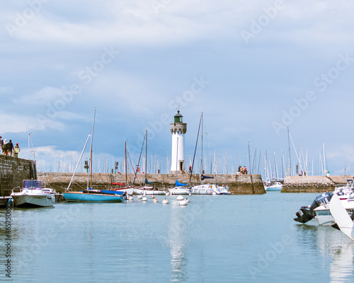 White lighthouse in a french harbour in a calm day