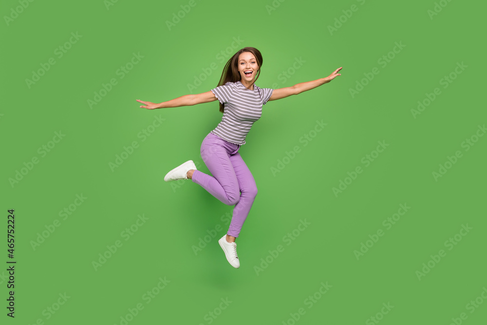 Full length body size view of attractive cheerful girl jumping fooling having fun rest isolated over bright green color background Full length body size view of attractive cheerful girl jumping fooling having fun rest isolated over bright green color background