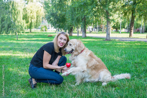 young woman with retriever and red heart in the park. © Tania