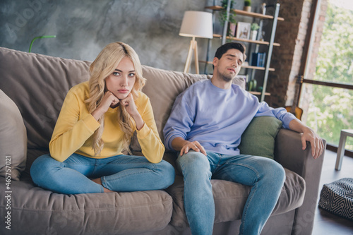 Photo of young couple unhappy sad negative disagreement conflict moody bad problem bored sit couch indoors