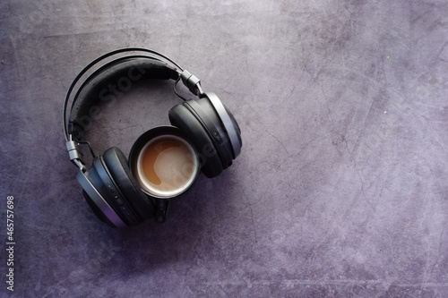 coffee and wireless headphones on black background 