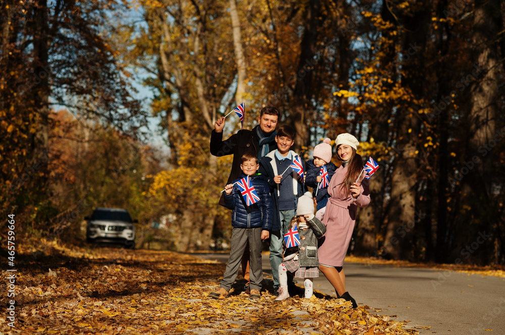 National holiday of United Kingdom. Large family with four kids holding british flags in autumn park. Britishness celebrating UK. National holiday of United Kingdom. Large family with four kids holding british flags in autumn park. Britishness celebrating UK.