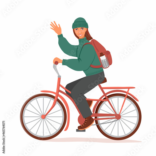 A smiling girl in a hat and a warm sweater rides a bicycle and waves her hand. On the back is a backpack. The concept of active lifestyle. Vector illustration in a flat style