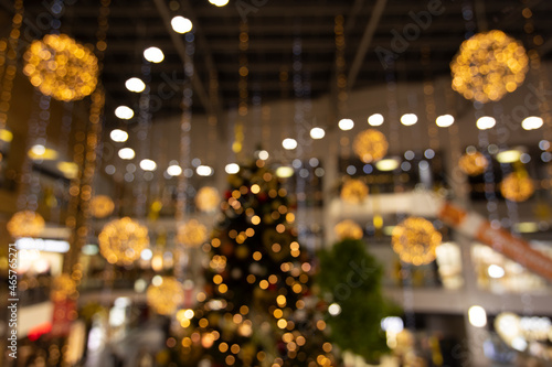 Shopping mall preparing for Christmas holidays indoor unfocused photography with yellow and golden garland and decoration illuminated objects © Артём Князь