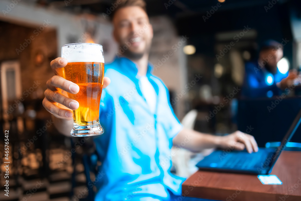 A man holding refreshing glass of beer