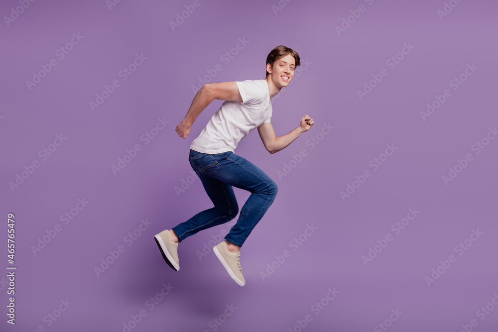 Full size profile side photo of young man good mood runner jumper sale isolated on violet color background