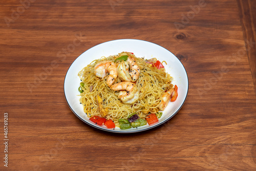 Chinese rice noodles with prawns and vegetables sautéed in the wok and with soy sauce