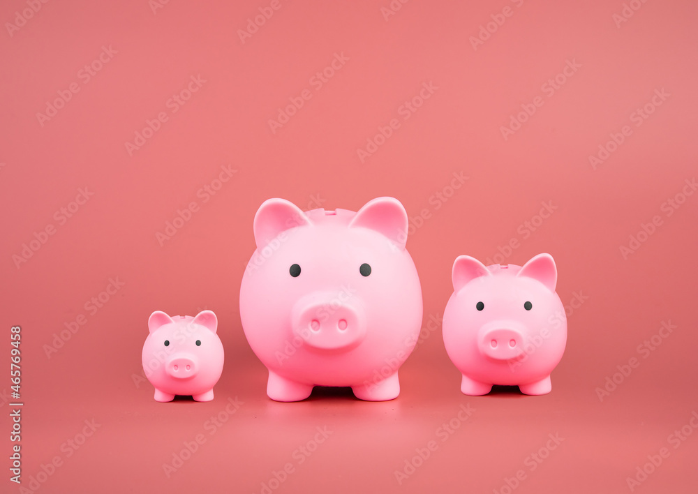 Savings, investments and interest. Three pink pig piggy banks on pink background. with copy space