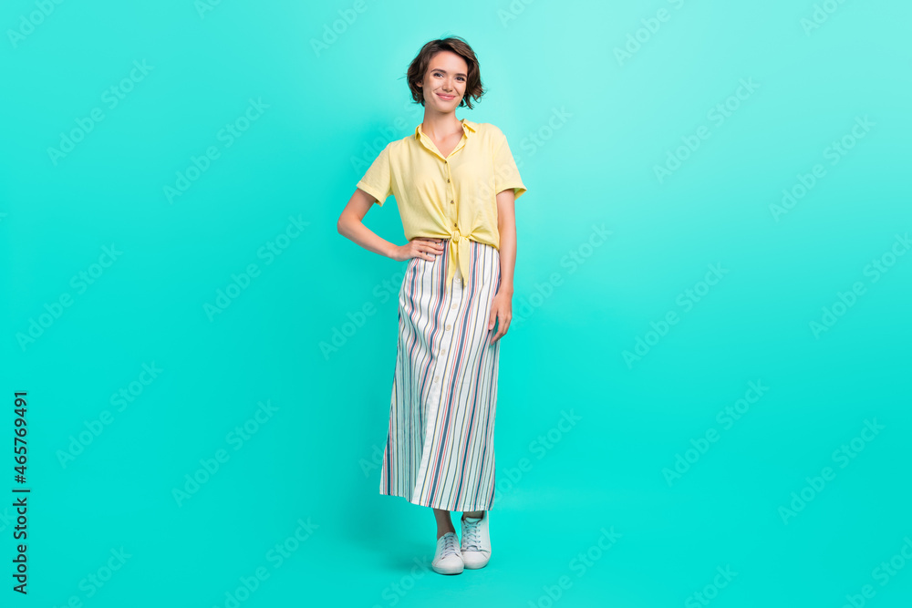 Full length photo of young attractive girl happy positive smile hand on waist isolated over turquoise color background Full length photo of young attractive girl happy positive smile hand on waist isolated over turquoise color background