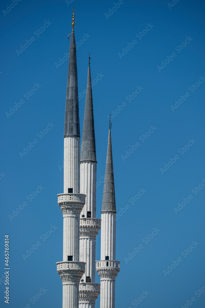 Trio of sharp white Ottoman architecture minarets of the great mosque of Mersin in Turkey