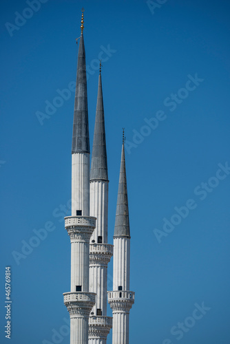 Trio of sharp white Ottoman architecture minarets of the great mosque of Mersin in Turkey