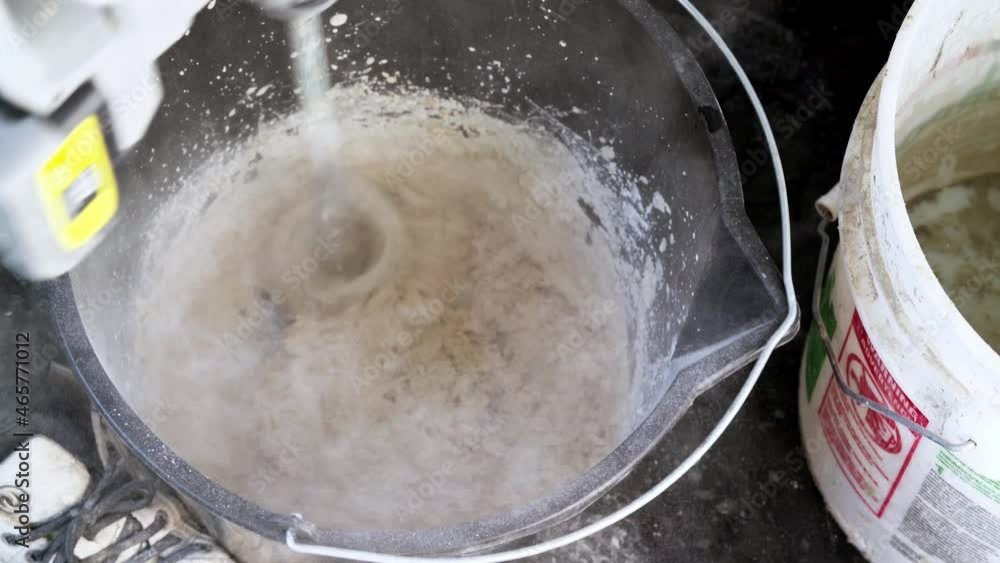 Mixing Plaster Filler Mixture In A Bucket Using An Electric Mixer Mixing Plaster Filler Mixture In A Bucket Using An Electric Mixer